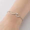 Primer plano de una pulsera minimalista de plata con diseño de olas - Color Acero
