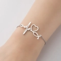 Bracciale minimalista in argento con cuore stetoscopio ed ECG al polso femminile - Color Acciaio