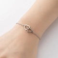 Pulsera plateada con dos corazones entrelazados y elegante cadena metálica para mujer - Color Acero