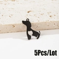 Detalle de cinco colgantes de perro negro mate con corazón hueco sobre piedra - Negro