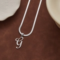 Collier maille serpent argenté avec pendentif lettre G cursive sur daim marron - Lettre G