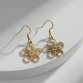 Pendientes de flores caladas doradas con gancho en un pedestal blanco - Dorado