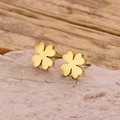 Detalle de pendientes de trébol dorado sobre una piedra natural de color rosa claro - Dorado