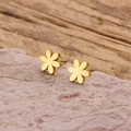 Macro-detail van gouden bloemknopjes met een matte afwerking op een roze natuursteen - Goud