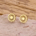 Detalle de pendientes de flores huecas en oro de 18k sobre una piedra mineral rosa - Dorado