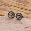 Detail of bohemian black shell studs on pink stone background with rustic wooden texture - Black