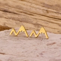 Vista macro de pendientes de botón dorados con forma de montaña en base de piedra - Dorado