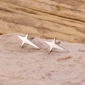 Elegant minimalist silver four-pointed star stud earrings with a polished mirror finish - Steel