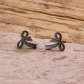 Detalle de pendientes de lazo en acero inoxidable negro mate sobre base de piedra - Negro