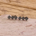 Detailopname van geometrische matzwarte oorbellen met drie verbonden ruiten - Zwart