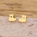 Golden Christmas stocking earrings with star cutout on a natural stone display - Gold