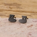 Close-up of black boot-shaped earrings with star cutout on a pink stone background - Black