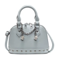 Macro shot of light blue shell bag with silver chain, dice charms, and rivet details - Blue