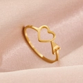 Bague ouverte en cœur doré avec flèche de Cupidon sur un élégant tissu en soie rose - Flèche de Coeur Dorée