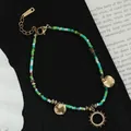 Buntes Boho-Perlenarmband mit goldenem Sonnenanhänger und verstellbarem Karabinerverschluss - Sonnenanhänger Stil / Grüne Sonne