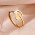 Bague ouverte en forme de note de musique dorée sur un tissu en soie rose texturé - Note de Musique Or