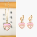 Détails de l'ensemble collier et boucles d'oreilles cœur en émail rose avec motif œil - Rose