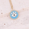 Macro-opname van gouden boze oog hanger met blauw email op natuurstenen achtergrond - Meerblauw
