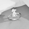 Nahaufnahme eines silbernen verstellbaren Ringes in minimalistischer Welpenform auf Stein - Stahl Sitzender Hund