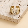 Stijlvolle gouden gelaagde V-ring met fonkelende kristallen op een stenen achtergrond - Verstelbaar Open / Goud V-Vorm Ingelegde Zirkonia