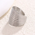 Anello aperto a onde argentate con superficie testurizzata e design traforato - Color Acciaio