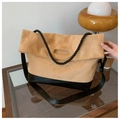 Detail of camel suede tote bag with rope handles and black leather base on a side table - Khaki