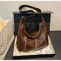Detail view of a vintage dark brown textured hobo bag with silver zippers in a gift box - Brown