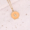 Collana dorata con pendente in smalto arancione e dettaglio foglia su fondo pietra - Foglia Rotonda Arancione