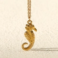 Vista macro di una collana con ciondolo a forma di cavalluccio marino in oro 18k con maglia fine - Cavalluccio marino / Oro