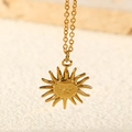 Detailed close-up of a radiant golden sun face pendant necklace with fine chain - Sun Face / Gold