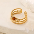 Detailaufnahme des mehrlagigen goldenen Edelstahlrings mit Tigerauge-Stein und Zirkon - Braun
