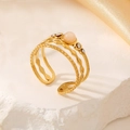 Detailed view of a triple-layered gold ring with peach stone and white rhinestones - Pink