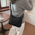 Detail of black pleated quilted shoulder bag with wave pattern and adjustable strap - Black