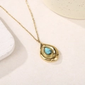 Détail macro du pendentif en turquoise goutte sur une chaîne en acier doré - Turquoise Bleue
