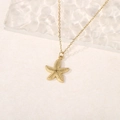 Detail of a 18k gold starfish pendant with fine textured surface on a beige background - Starfish Pendant (A4550)