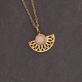 Dettaglio macro della collana a ventaglio dorata con pietra rosa su fondo in pietra - Pendaglio Cavo a Ventaglio (Rosa)