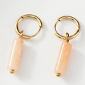 Détail de créoles dorées avec pendentifs cylindriques en pierre naturelle rose poli - Rose