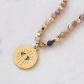 Boheems kralensnoer van titaniumstaal met gouden evil eye hanger en kleurrijke stenen - Bruine Evil Eye Ronde Hanger