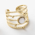 Detailopname van meerlaagse vergulde ring met witte edelsteen en gehamerde textuur - Holle Gelaagde Open Stijl / Goud Met Witte Natuursteen