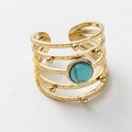 Detail van een boheemse gouden ring met meerdere lagen, turquoise steen en hamertextuur - Holle Gelaagde Open Stijl / Goud Met Blauwe Natuursteen