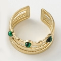 Macro shot of gold layered ring with green gemstones and hammered texture on metal bands - Gold with Green Gemstone