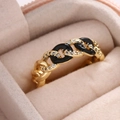 Goldener Kettenring mit schwarzer Emaille und funkelnden Zirkonia in einer Schmuckbox - Schwarz