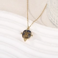 Détail du collier en acier doré avec pendentif en pierre bleue et feuilles d'or - Bleu