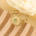 Exquisite goldene Sonnenstrahl-Manschette mit grünem Edelstein und Perlenstruktur - Grün