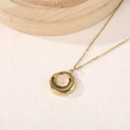 Détail de collier doré avec pierre précieuse rose clair et pendentif à double anneau - Quartz Rose