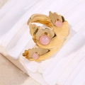 Anello a foglia dorata con tre pietre rosa su base bianca in vista macro a 45 gradi - Anello Aperto Foglia 3D / Rosa