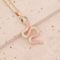 Détail macro du pendentif serpent avec émail rose, cristaux pavés et yeux verts sertis - Rose