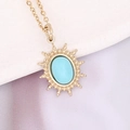 Vintage-Goldkette mit ovalem hellblauem Steinanhänger auf weißer Keramikoberfläche - Seeblau