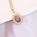 Detail einer Vintage-Goldkette mit ovalem lila Stein und Sonnenstrahl-Rahmen - Lila