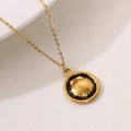 Gouden roestvrijstalen ketting met zwart emaille schelphanger en zonnestraalmotief - Zwart